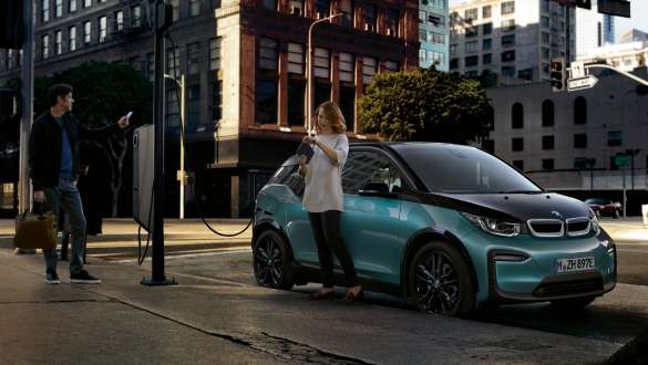 BMW i3 2018 at a public charging station Couple charging their BMW i3 at a public charging station I01 2018 Jucaro beige with Frozen Grey metallic highlight