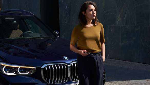 Woman in front of a BMW BMW Roadside Assistance Woman in front of a BMW