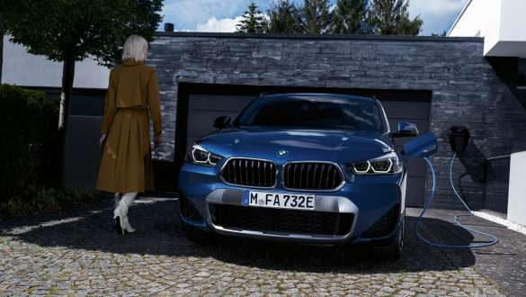 Plug-in hybrid BMW X2 xDrive25e F39 front view in front of garage Plug-in hybrid BMW X2 xDrive25e F39 front view in front of garage with model
