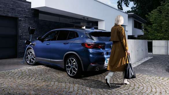 Plug-in hybrid BMW X2 xDrive25e F39 three-quarter rear view charging Plug-in hybrid BMW X2 xDrive25e F39 three-quarter rear view charging with model