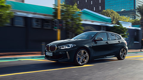 BMW M135i xDrive (F40) three-quarter side view driving in the city