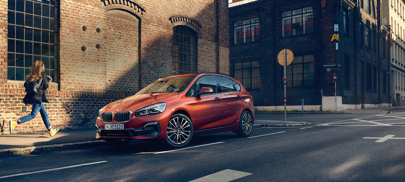 BMW 2 Series Active Tourer parking BMW 2 Series Active Tourer F45 Facelift 2018 Sunset Orange metallic three-quarter front view parking on the road