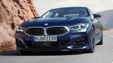 BMW 8 Series Gran Coupé (G16) three-quarter rear view driving