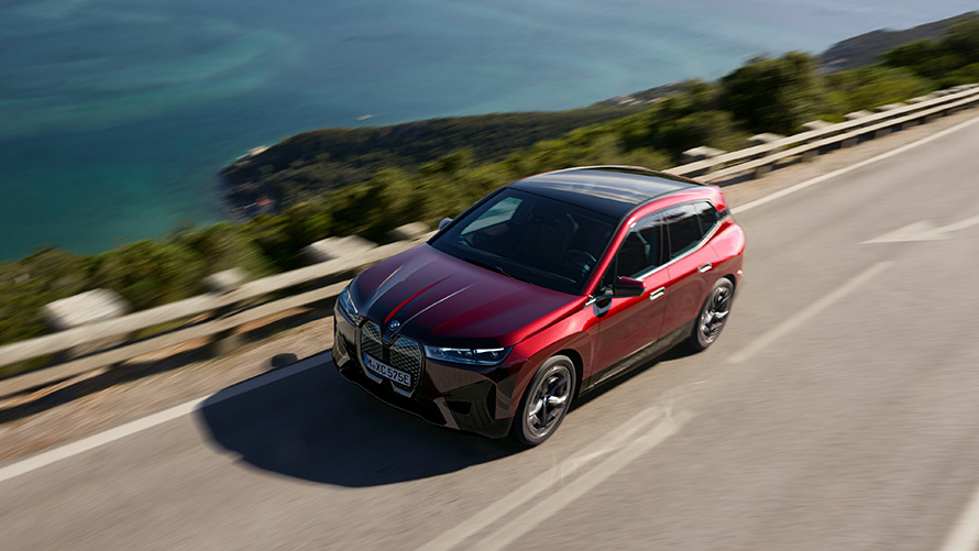 BMW iX i20 electric SUV BMW iX xDrive50 performance BMW iX i20 2021 electric SUV BMW iX xDrive50 Aventurin Red driving on a street performance