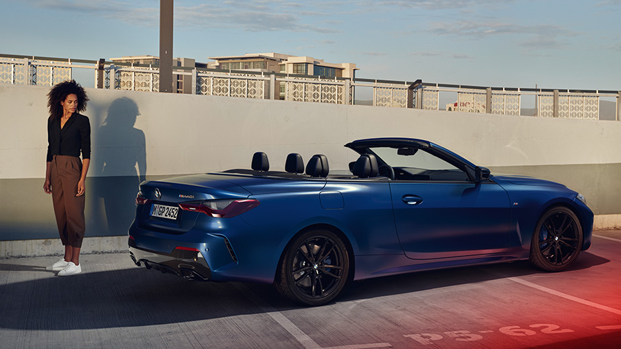 BMW Financial Services for the BMW 4 Series Convertible Woman standing behind BMW 4 Series Convertible on parking level BMW Financial Services