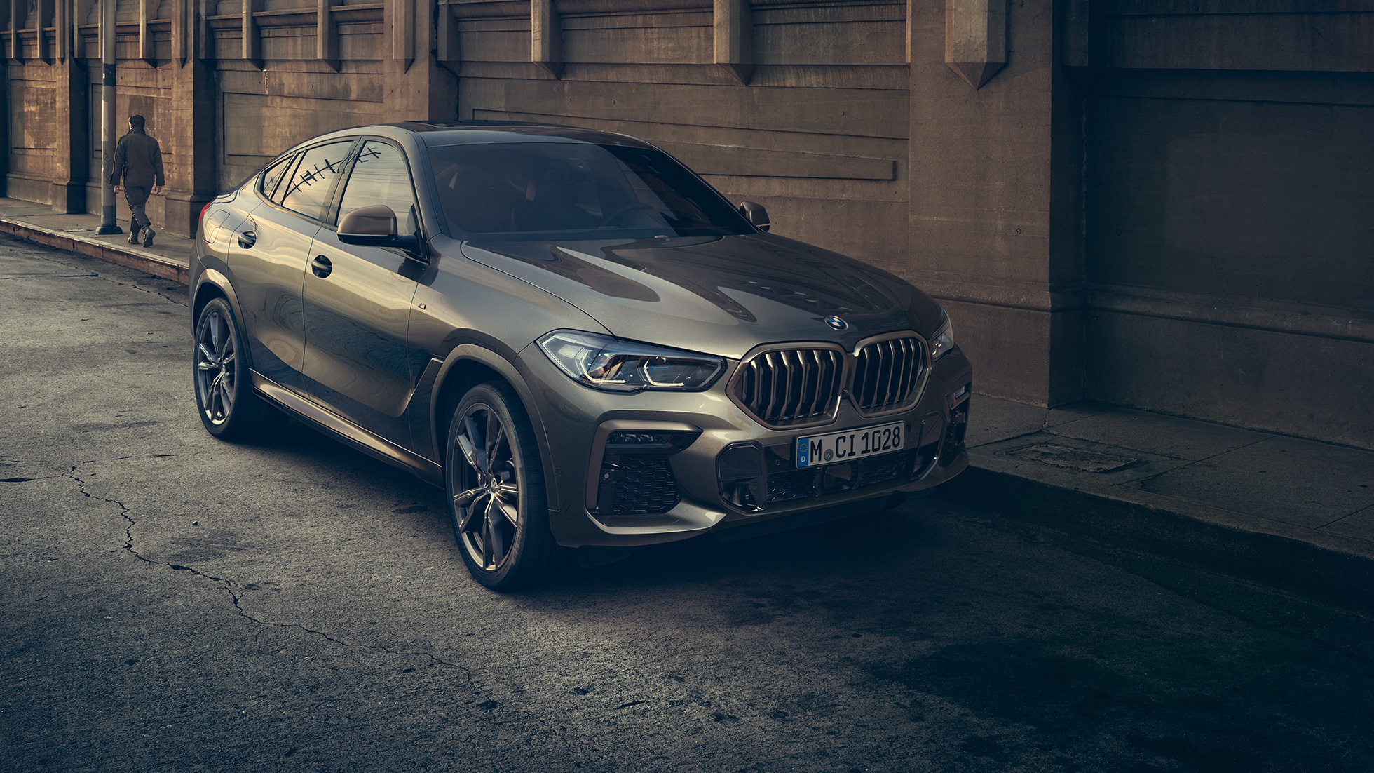 BMW X6 M50i standing. BMW X6 M50i in three-quarter front perspective standing in front of an urban setting.