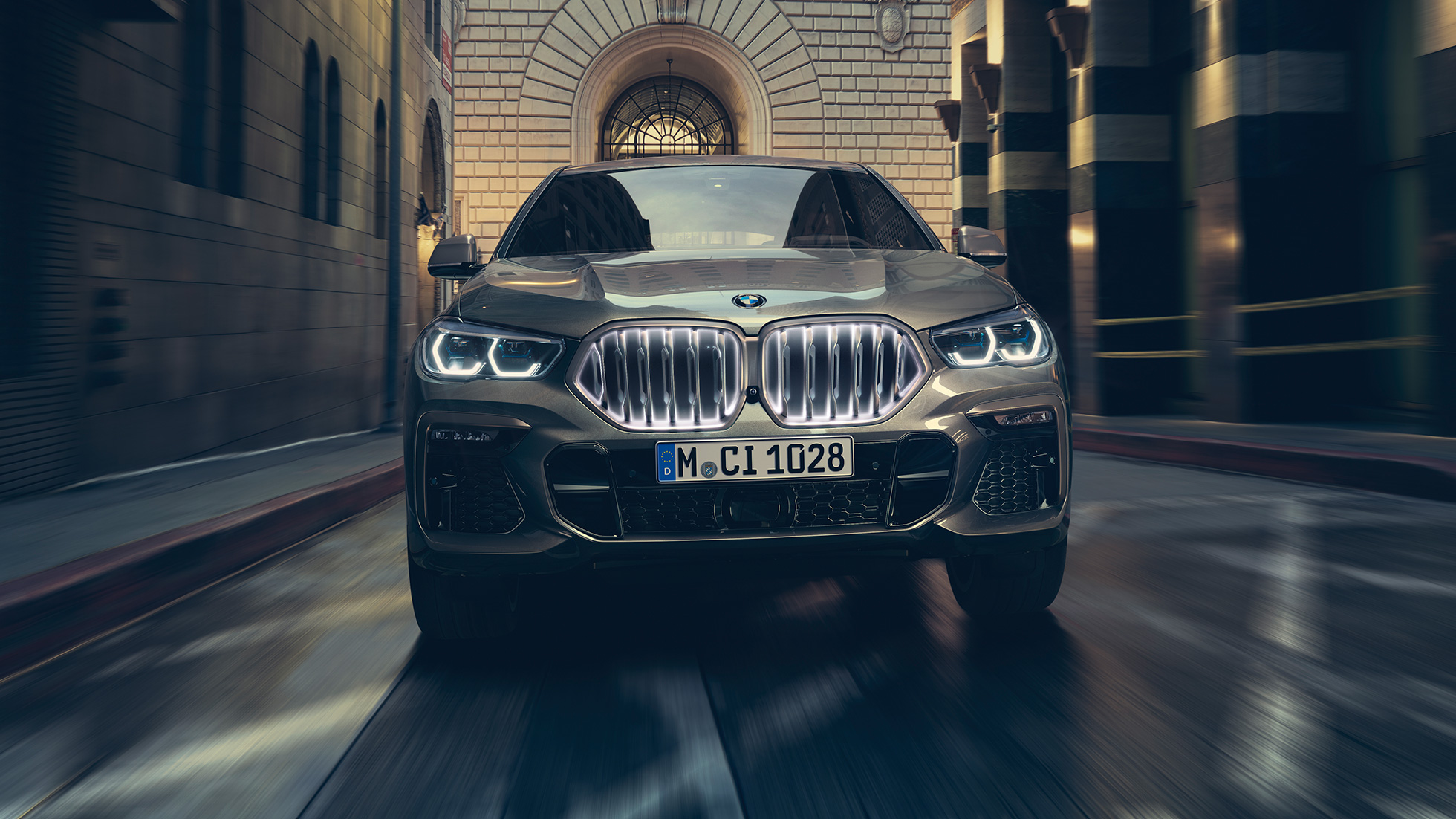 BMW X6 M50i with BMW kindey grille ‘Iconic Glow‘. BMW X6 M50i in front perspective in front of an urban setting.