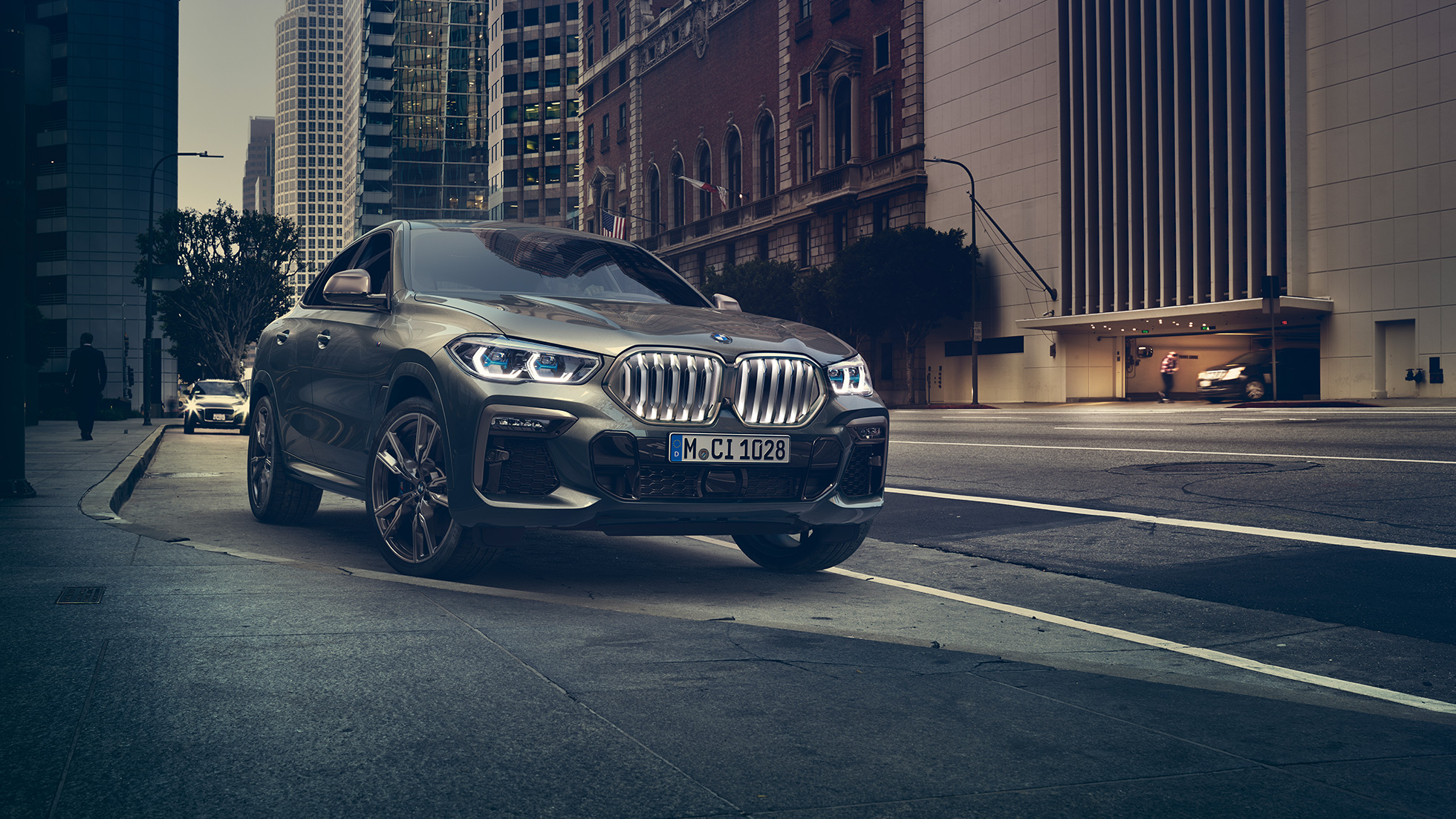 BMW X6 M50i standing. BMW X6 M50i in three-quarter front perspective standing in front of an urban setting.