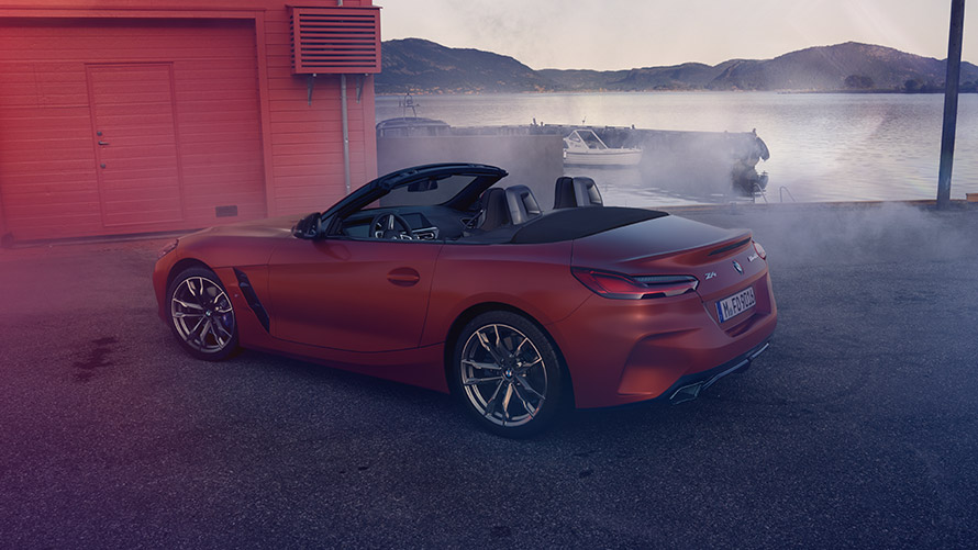 Rear view orange BMW Z4 First Edition Rear view orange BMW Z4 First Edition in front of red house at the shore