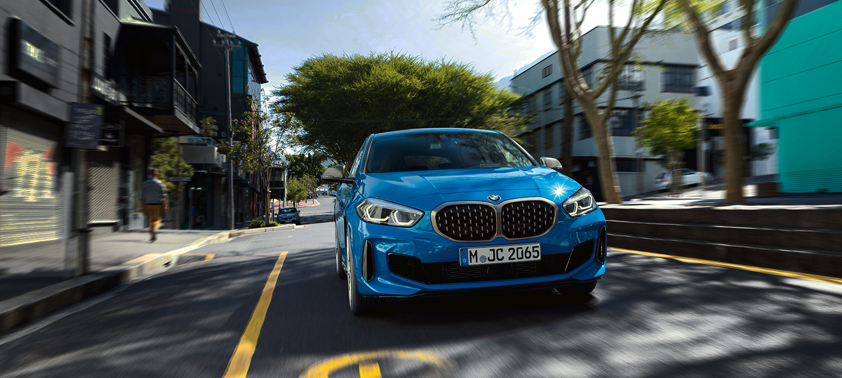 BMW 1 Series in Misano Blue metallic, front view driving.